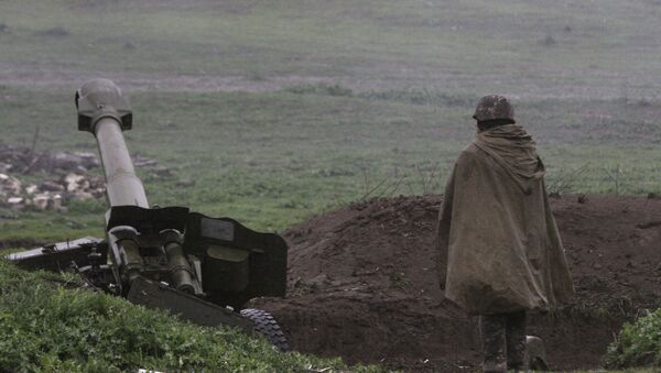 Јерменски војник самоодбране Нагорно-Карабаха стоји испред топа у граду Мартакерт где су ескалирали сукоби са Азербејџанцима. - Sputnik Србија