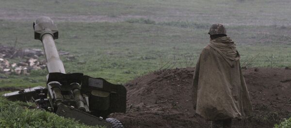 Јерменски војник самоодбране Нагорно-Карабаха стоји испред топа у граду Мартакерт где су ескалирали сукоби са Азербејџанцима. - Sputnik Србија