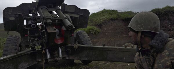 Јерменски војник самоодбране Нагорно-Карабаха стоји испред топа у граду Мадагис где су ескалирали сукоби са Азербејџанцима. - Sputnik Србија