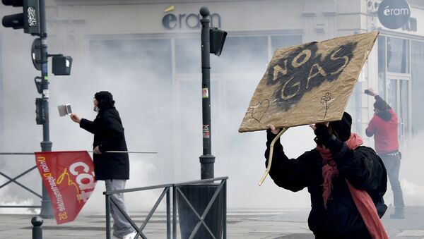 Демонстрант са транспарентом на протесту против закона о раду у француском граду Рен током сукоба са полицијом - Sputnik Србија