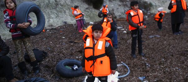 Мигранти са појасима за спасавање у турској луци Дикили чекају укрцавање на брод до грчког острва Лезбос - Sputnik Србија