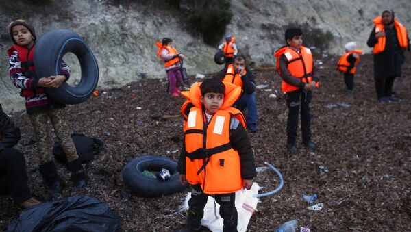 Мигранти са појасима за спасавање у турској луци Дикили чекају укрцавање на брод до грчког острва Лезбос - Sputnik Србија
