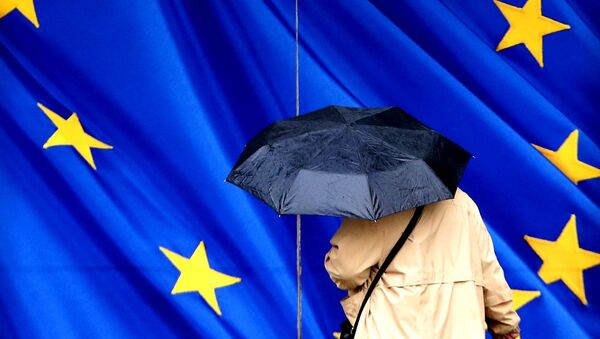 Žena sa kišobranom pored zastave EU - Sputnik Srbija