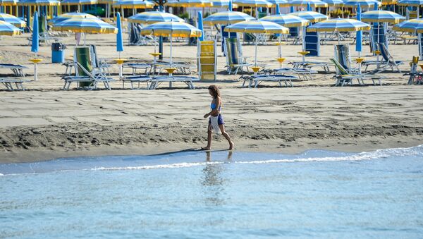 Žena šeta plažom u blizini Rima - Sputnik Srbija