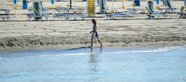 Žena šeta plažom u blizini Rima - Sputnik Srbija