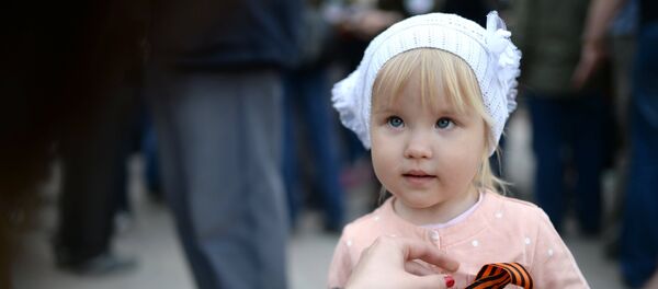 Devojčici kače  Georgijevsku lentu u Moskvi - Sputnik Srbija