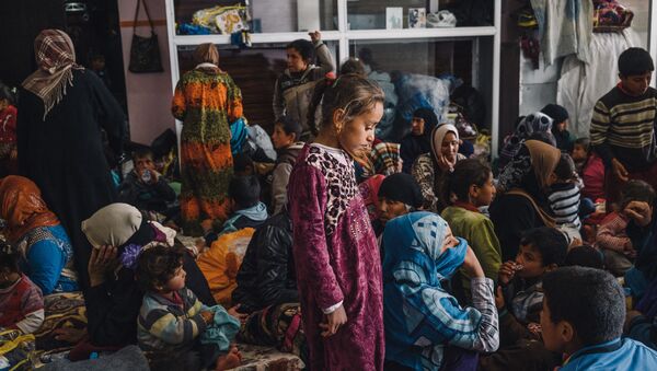 Devojčica stoji među ženama i decom u zgradi koja služi kao sklonište za civile u Mahmuru istočno od Mosula u Iraku - Sputnik Srbija