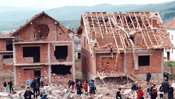 Ljudi šetaju pored ruševina, kada je raketa pogodila stambeni deo Surdulice, a tom prilikom je poginulo 17 civila, 28.aprila 1999. godine - Sputnik Srbija
