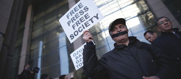 Turski novinari pokrivaju usta crnom trakom pre suđenja Kanu Dundaru, glavnom uredniku opozicionih novina Džumhurijet i Erdemu Gulu, predstavniku iz Ankare, ispred suda u Istambulu. - Sputnik Srbija