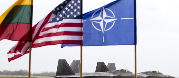 Амерички Ф-22 Раптор борбени авиони стоје на писти у ваздухопловној бази у Литванији, поред застава Литваније , НАТО и САД - Sputnik Србија