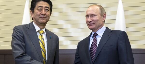 Ruski predsednik Vladimir Putin i japanski premijer Šinzo Abe rukuju se pre sastanka u Sočiju. - Sputnik Srbija