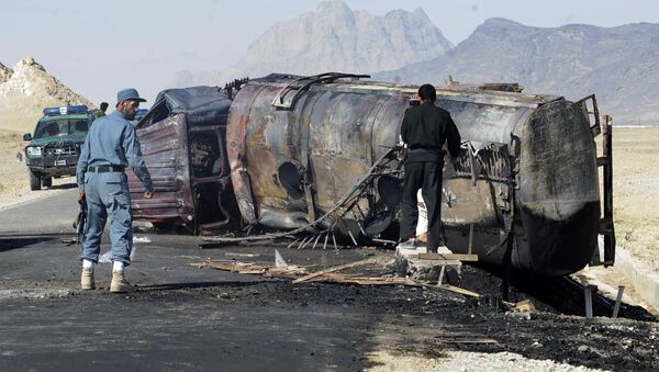 Avganistanski policajci stoje pored izgorele cisterne sa benzinom. - Sputnik Srbija