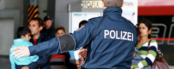 Полицајац усмерава мигранте на железничкој станици у Минхену. Полицајац усмерава мигранте на железничкој станици у Минхену. - Sputnik Србија