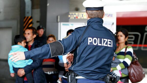 Полицајац усмерава мигранте на железничкој станици у Минхену. - Sputnik Србија