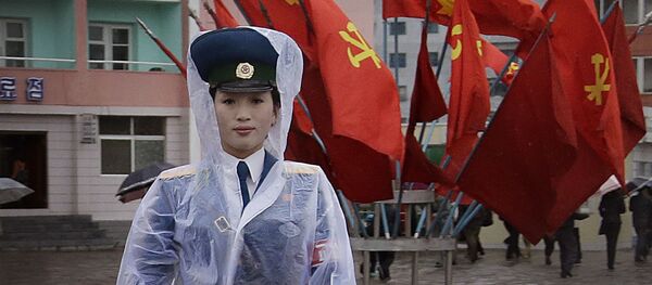 Severnokorejska saobraćajna policajka ispred zastava vladajuće Komunističke partije u Pjongjangu Severnokorejska saobraćajna policajka ispred zastava vladajuće Komunističke partije u Pjongjangu - Sputnik Srbija