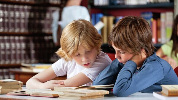 Dečaci čitaju knjigu u biblioteci - Sputnik Srbija