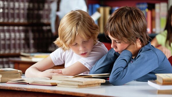 Дечаци читају књигу у библиотеци - Sputnik Србија