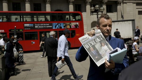 Novinar drži primerak novina tokom vođenja reportaže ispred Banke Engleske u Londonu - Sputnik Srbija