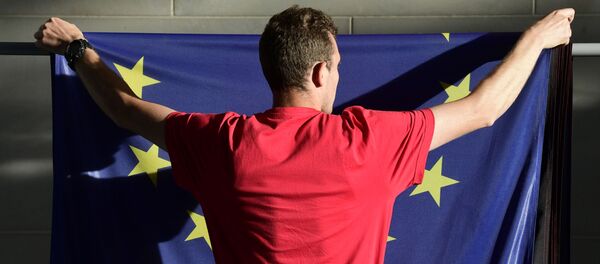 Čovek kači zastavu EU - Sputnik Srbija