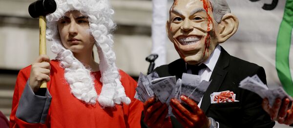 A protester wearing a former British Prime Minister Tony Blair mask, right, and another dressed as a judge pose for the media on a stage outside the Queen Elizabeth II Conference Centre in London, shortly before the publication of the Chilcot report into the Iraq war, Wednesday, July 6, 2016. A protester wearing a former British Prime Minister Tony Blair mask, right, and another dressed as a judge pose for the media on a stage outside the Queen Elizabeth II Conference Centre in London, shortly before the publication of the Chilcot report into the Iraq war, Wednesday, July 6, 2016. - Sputnik Србија