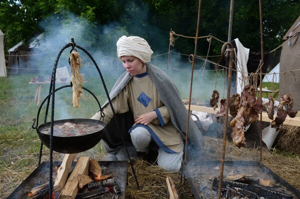Девојка припрема месо на традиционалном међународном фестивалу „Времена и епохе“ у националном парку Коломенско у Москви. - Sputnik Србија