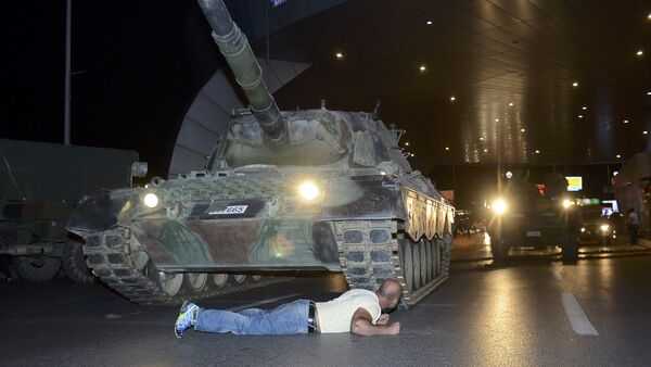 Čovek leži ispred tenka turske vojske na aerodromu Ataturk u Istanbulu - Sputnik Srbija