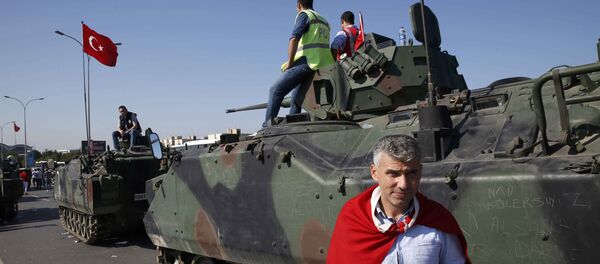 Човек са турском заставом поред војних возила у Истанбулу након покушаја државног удара у Турској - Sputnik Србија
