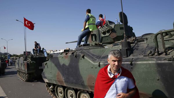 Човек са турском заставом поред војних возила у Истанбулу након покушаја државног удара у Турској - Sputnik Србија