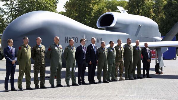 Generalni sekretar NATO-a Jens Stoltenberg (S) sa zvaničnicima i vojnim osobljem ispred bespilotne letelice tokom samita NATO-a u Varšavi. - Sputnik Srbija