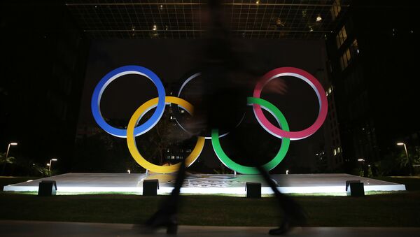 Жена пролази поред олимпијских кругова испред зграде у Сао Паолу. - Sputnik Србија
