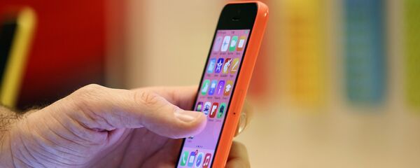 Žena gleda u telefon ajfon u jednoj od Eplovih radnji u Parizu. - Sputnik Srbija