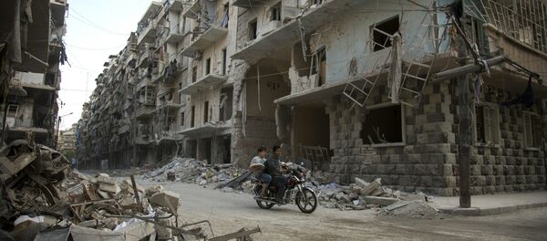 Сиријци се возе мотором поред оштећених зграда у источном делу Алепа. - Sputnik Србија