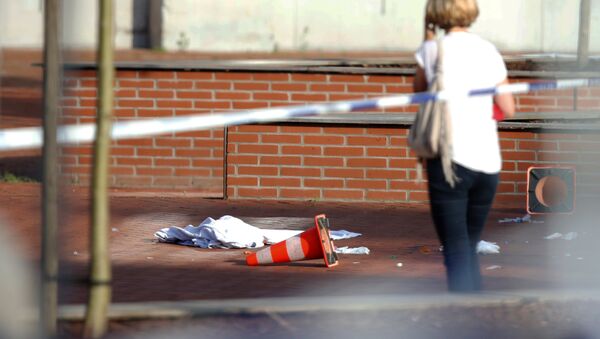 Žena na mestu zločina gde je napadač sa mačetom napao dve policajke u gradu Šarloa u Belgiji. - Sputnik Srbija