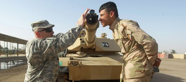 Амерички војни тренер показује ирачком војнику како се користи колиматор за калибрацију цеви једног од тенкова „Абрамс” током тренинга у основи комплексу Таји, где се налазе ирачке и америчке трупе. Амерички војни тренер показује ирачком војнику како се користи колиматор за калибрацију цеви једног од тенкова „Абрамс” током тренинга у основи комплексу Таји, где се налазе ирачке и америчке трупе. - Sputnik Србија