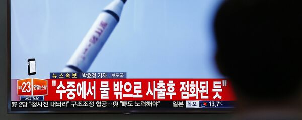 Јужнокорејанац у Сеулу гледа снимак лансирања ракете у Северној Кореји. - Sputnik Србија