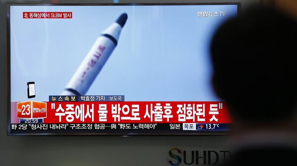Јужнокорејанац у Сеулу гледа снимак лансирања ракете у Северној Кореји. - Sputnik Србија