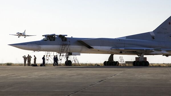 Ruski bombarder Tu-22M3 stoji na pisti dok je drugi avion sleće u vazduhoplovnu bazu Hamadan, Iran. - Sputnik Srbija
