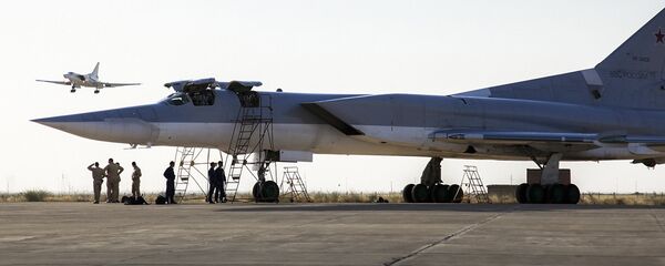 Руски бомбардер Ту-22М3 стоји на писти док је други авион слеће у ваздухопловну базу Хамадан, Иран. - Sputnik Србија