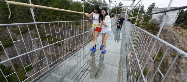 Туристи шетају по стакленом мосту у Националном парку Шиниужај у кинеској провинцији Хунан. Туристи шетају по стакленом мосту у Националном парку Шиниужај у кинеској провинцији Хунан. - Sputnik Србија