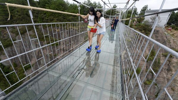 Turisti šetaju po staklenom mostu u Nacionalnom parku Šiniužaj u kineskoj provinciji Hunan. - Sputnik Srbija