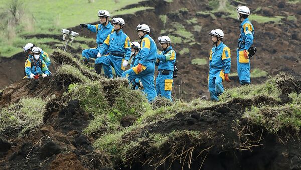 Policemen ckeck a landslide site before searching for missing people in Minami-Aso, Kumamoto prefecture, on April 22, 2016 - Sputnik Srbija