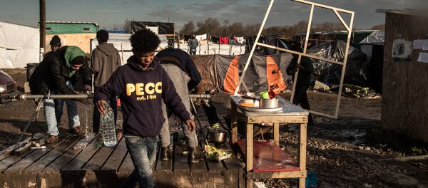 Men wash up at a water source at the migrant camp known as the Jungle in Calais on December 7, 2015 Men wash up at a water source at the migrant camp known as the Jungle in Calais on December 7, 2015 - Sputnik Србија