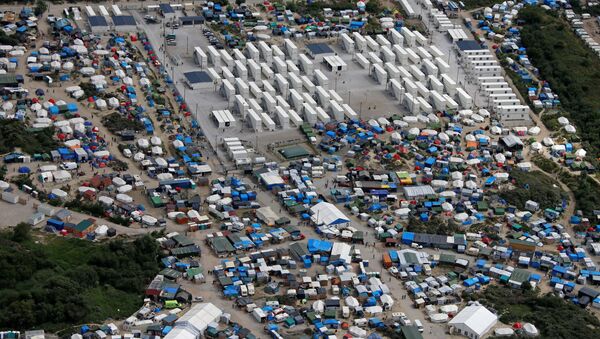 Aerial view of a makeshift camp as containers (rear) are put into place to house migrants living in what is known as the Jungle, a sprawling camp in Calais, France, August 14, 2016. - Sputnik Srbija
