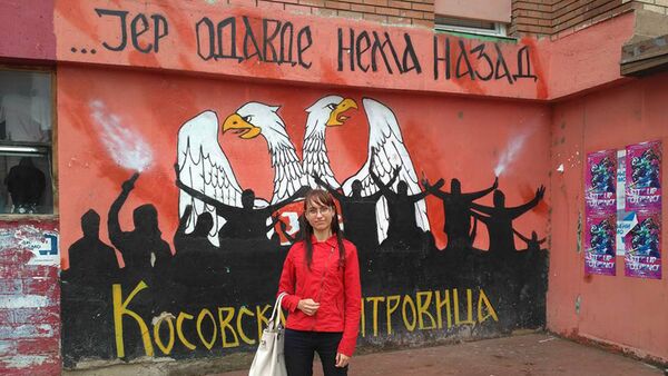 Ruska novinarka Oksana Sazonova ispred grafita u Kosovskoj Mitrovici - Sputnik Srbija
