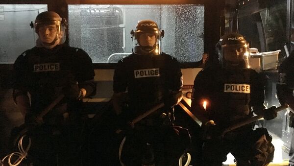 Policajci stoje ispred autobusa u Šarlotu tokom protesta zbog ubistva Kita Lamonta Skota. - Sputnik Srbija