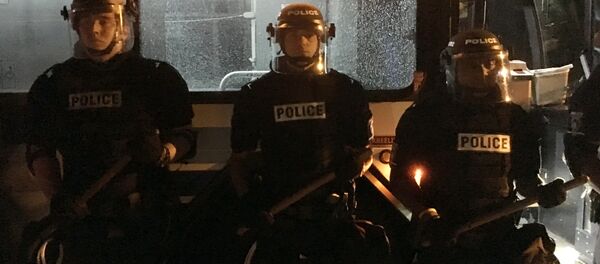 Policajci stoje ispred autobusa u Šarlotu tokom protesta zbog ubistva Kita Lamonta Skota. - Sputnik Srbija
