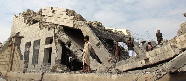 Људи стоје на рушевинама школе коју су бомбардовали Саудијци у северозападном јеменском граду Сада - Sputnik Србија