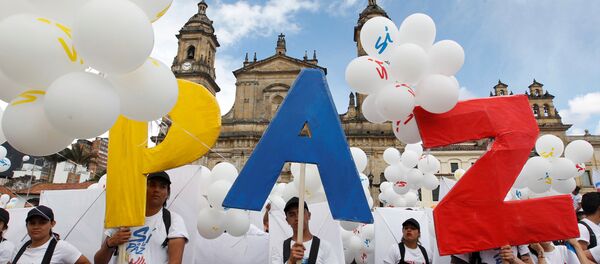 Ljudi stoje sa natpisom Mir na Bolivarovom trgu ispred katedrale u Bogoti, Kolumbija. - Sputnik Srbija