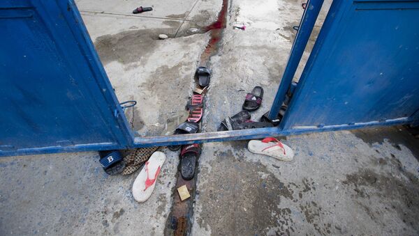 Sandale zatvorenika leže razbacane na glavnoj kapiji zatvora na Haitiju. - Sputnik Srbija