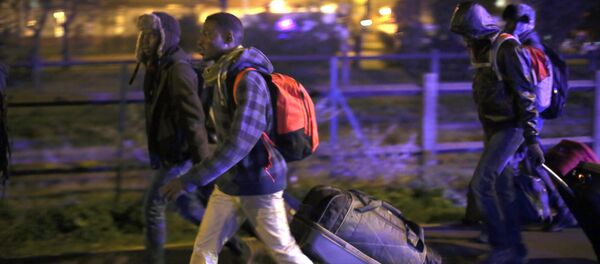 Migranti sa stvarima napuštaju kamp u blizini Kalea u Francuskoj. - Sputnik Srbija